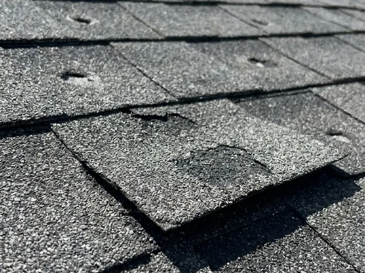 Cracked, lifting shingles on a roof